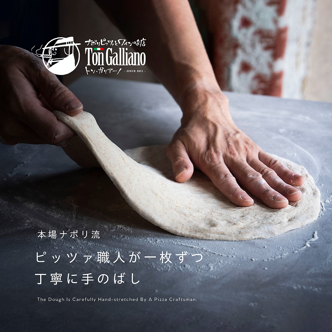 〝全粒粉配合のピザ生地を職人が手伸ばし