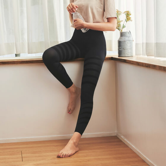 10段着圧レギンス クールタイプを着用して窓辺に腰かけている女性モデルの写真