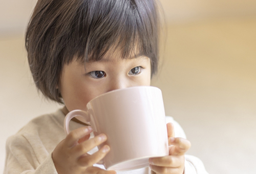 子供がマグカップで飲んでいる写真