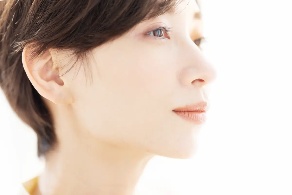 白い光の中で未来を見据え少しほほ笑む女性