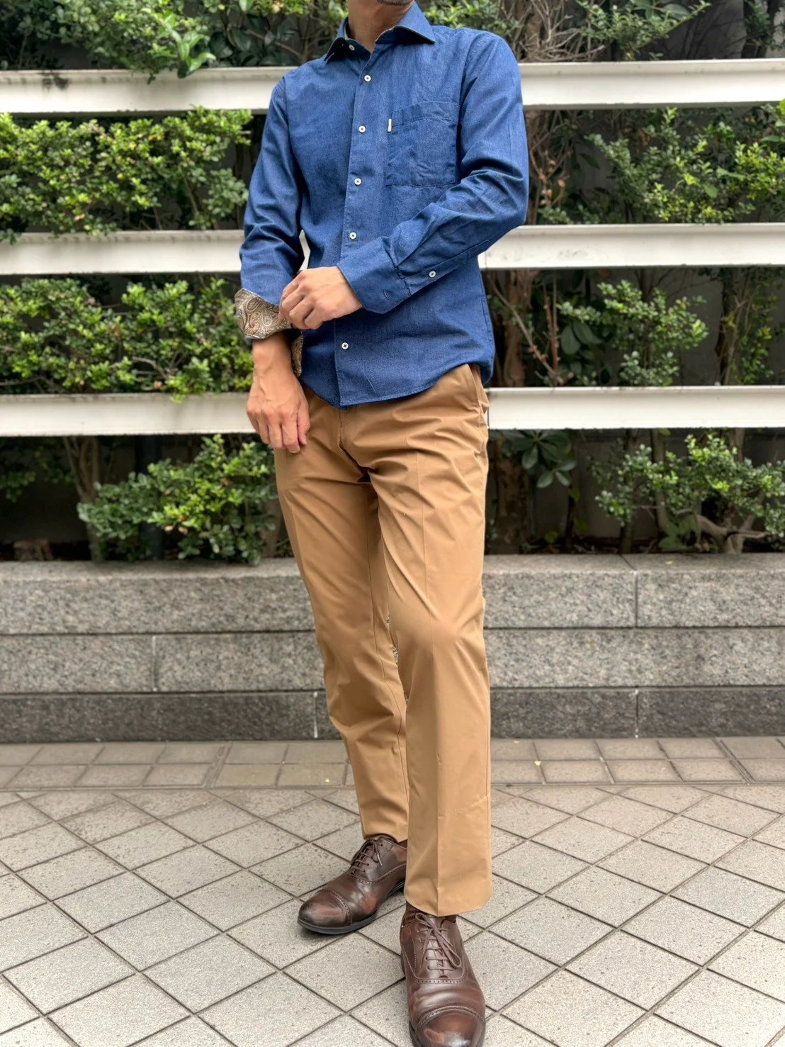 デニムシャツを一枚で着てベージュパンツと茶色の靴に合わせたスタイル