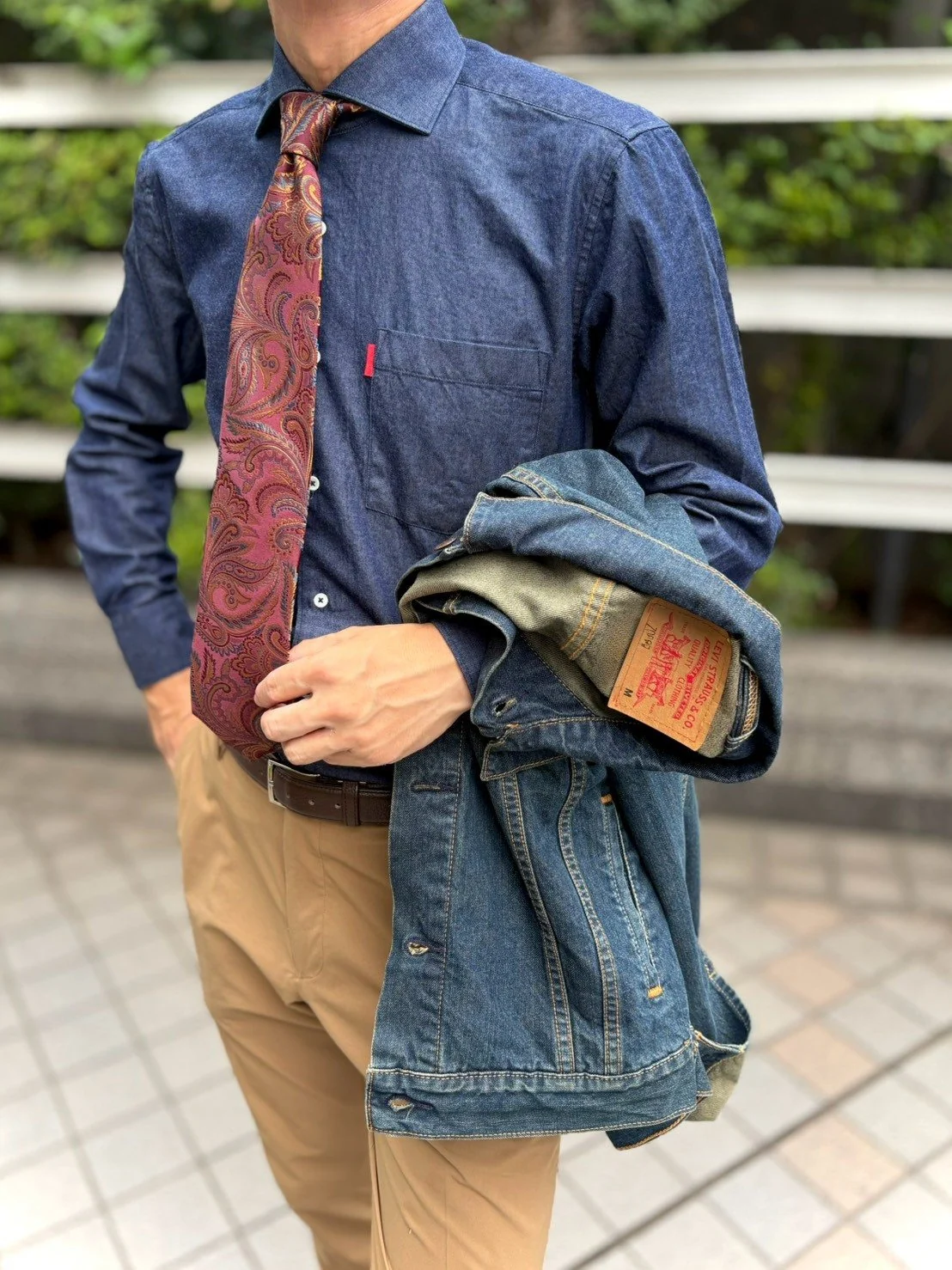 ネイビーのデニムシャツにワイン色のネクタイを合わせたスタイル