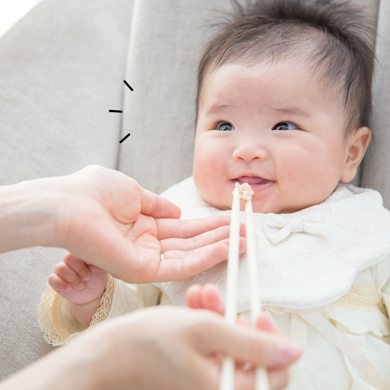 お食い初め儀式中に笑顔になる赤ちゃん