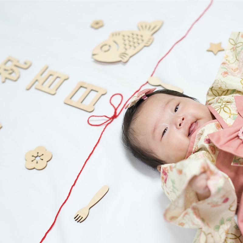 百日祝いのガーランドと笑顔の赤ちゃん