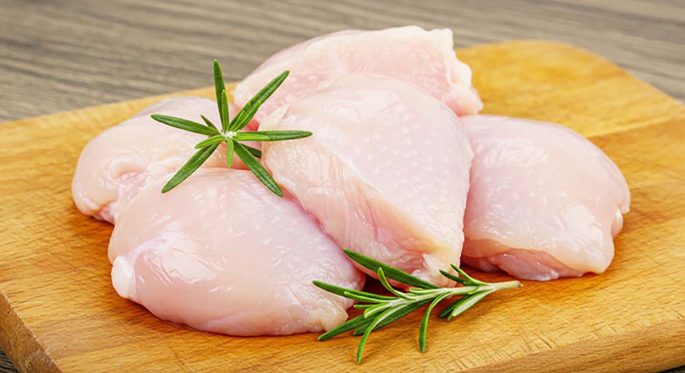 グランツで使用しているお肉のイメージ画像。木のまな板の上にぶつ切りのお肉が4つほどあり、香草が2本添えられている。