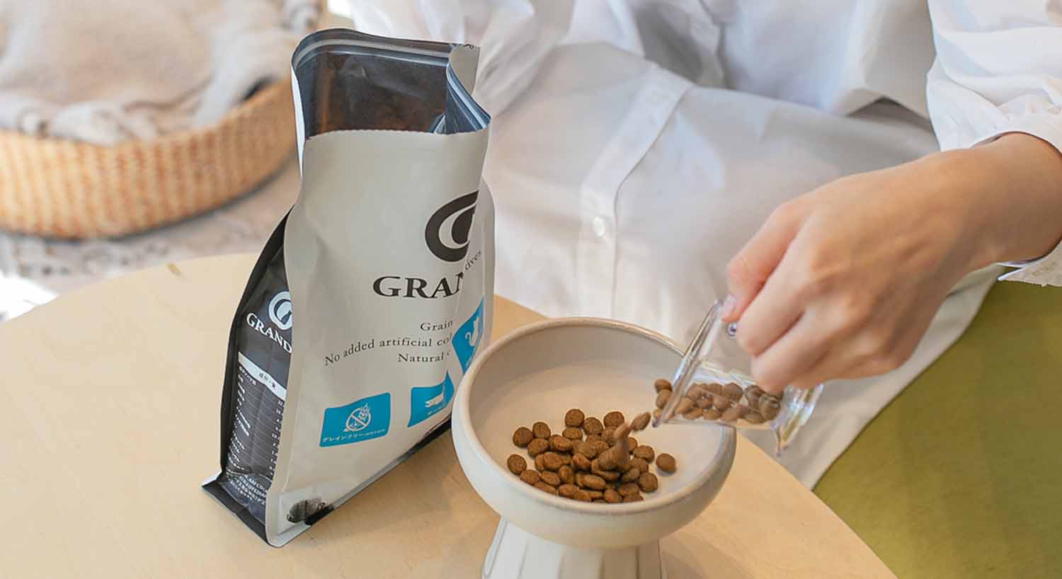 グランツのパッケージを開けて、フードを器に移している人間の様子