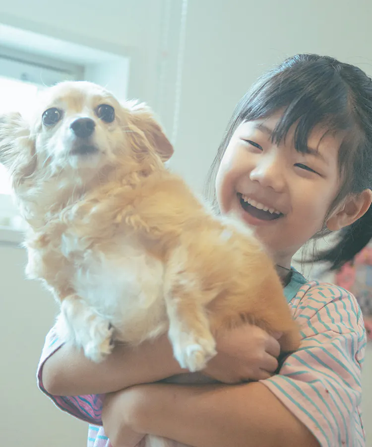 愛犬を抱いて笑う子ども