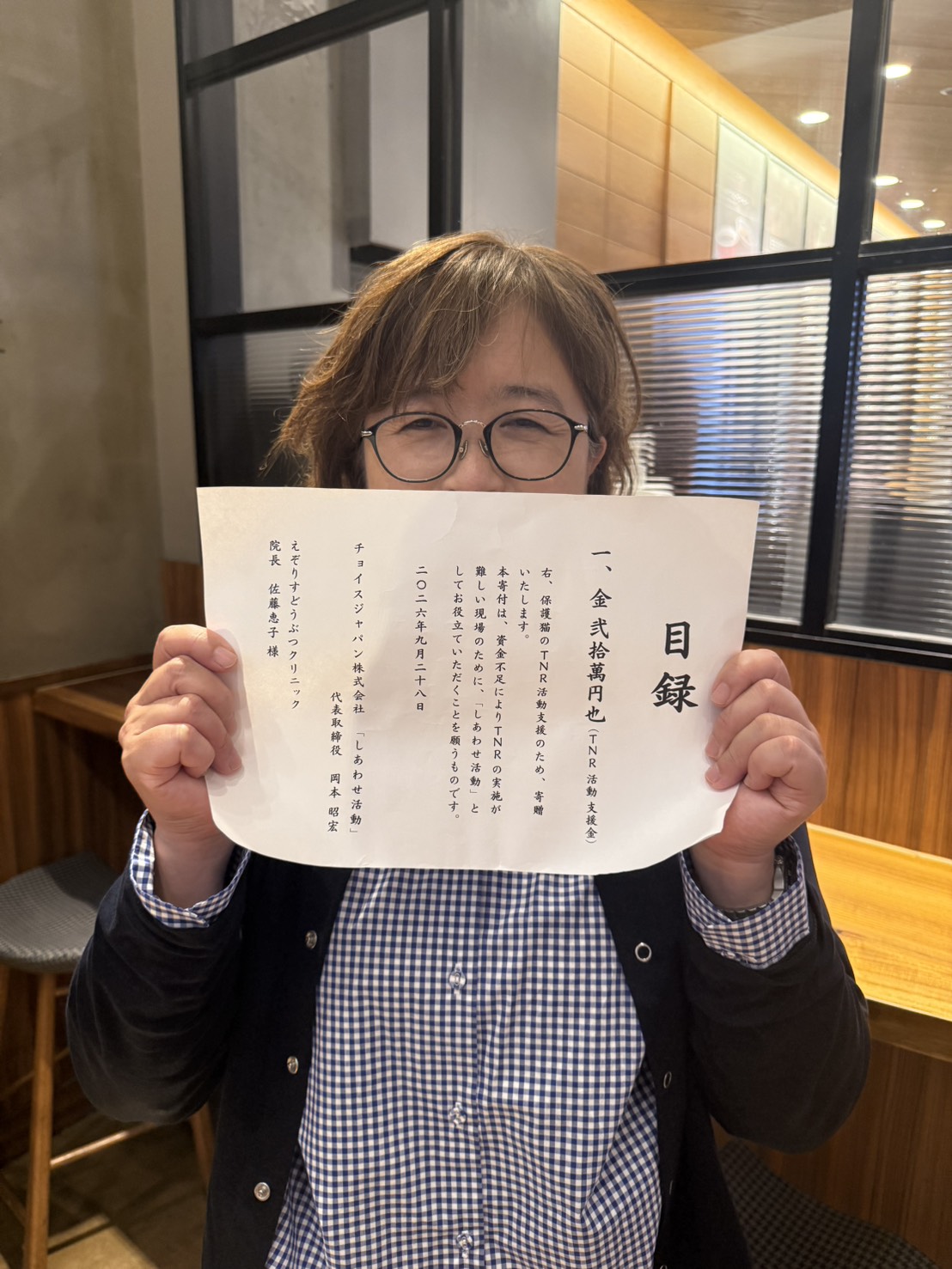 目録を手にする、えぞりすどうぶつクリニックの佐藤院長