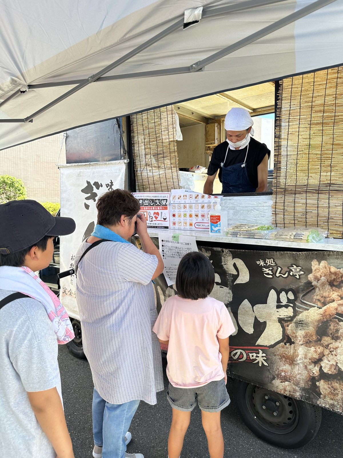 キッチンカーの前に並ぶ家族連れ