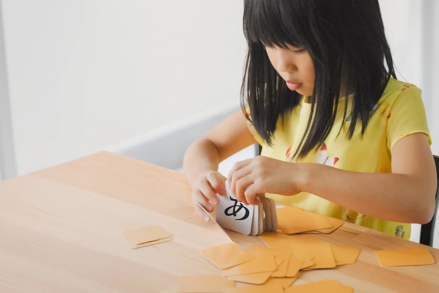 テーブルでカードを並べて遊ぶ女の子