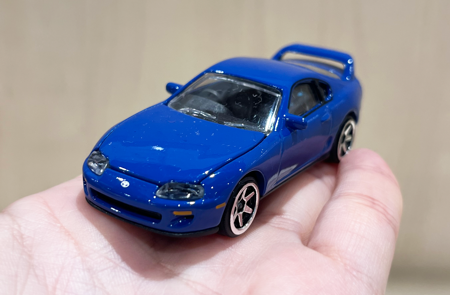 手に持ったトヨタ スープラのミニカーの接写写真