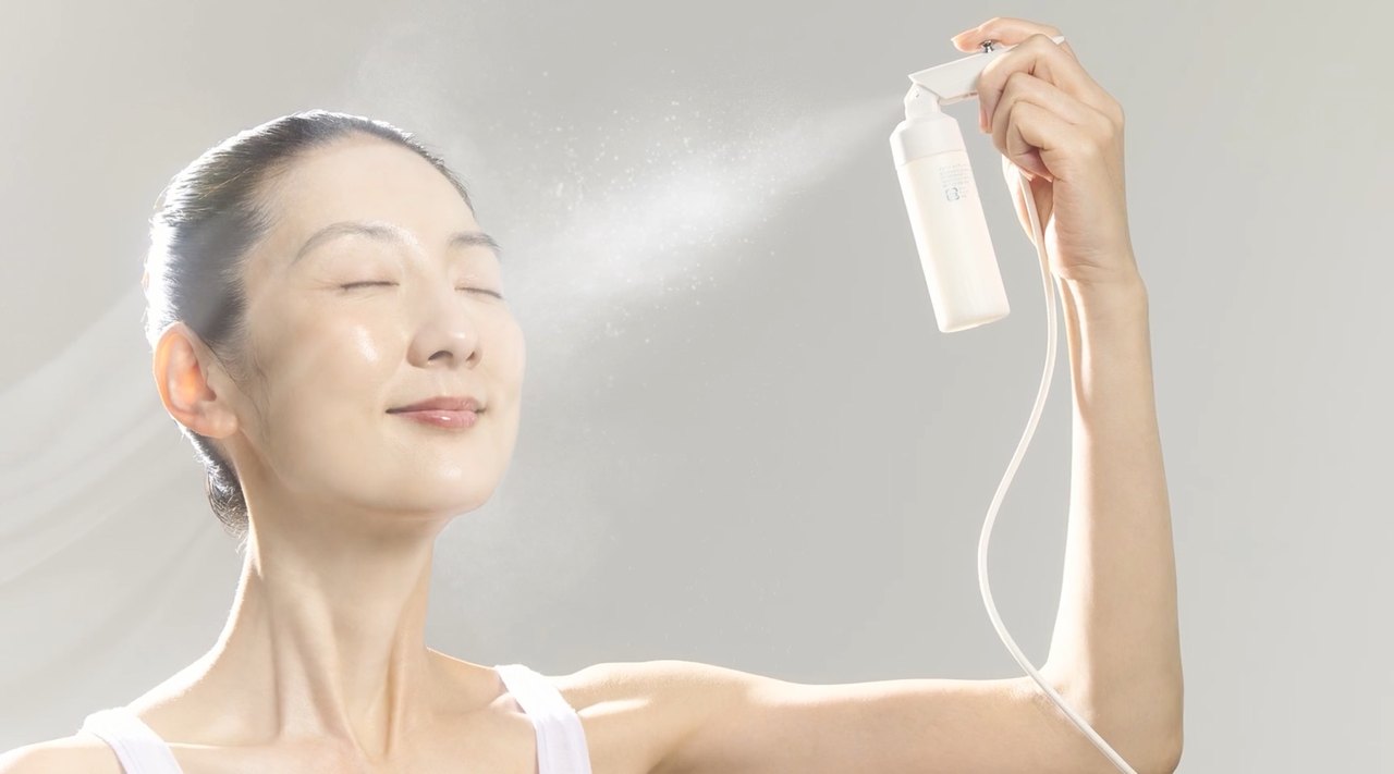 LUMI VEIL MILK をデバイスで顔に噴霧している様子