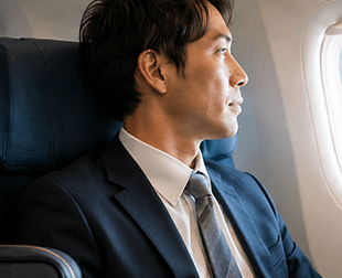 飛行機で移動する男性