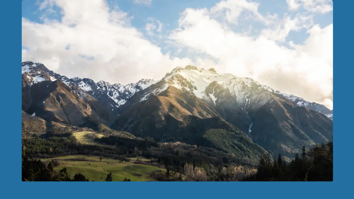 ニュージーランドの雪山と緑の牧場の壮大な風景