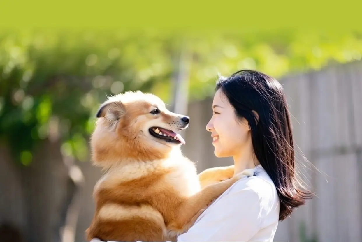 笑顔の女性が犬を抱いている写真