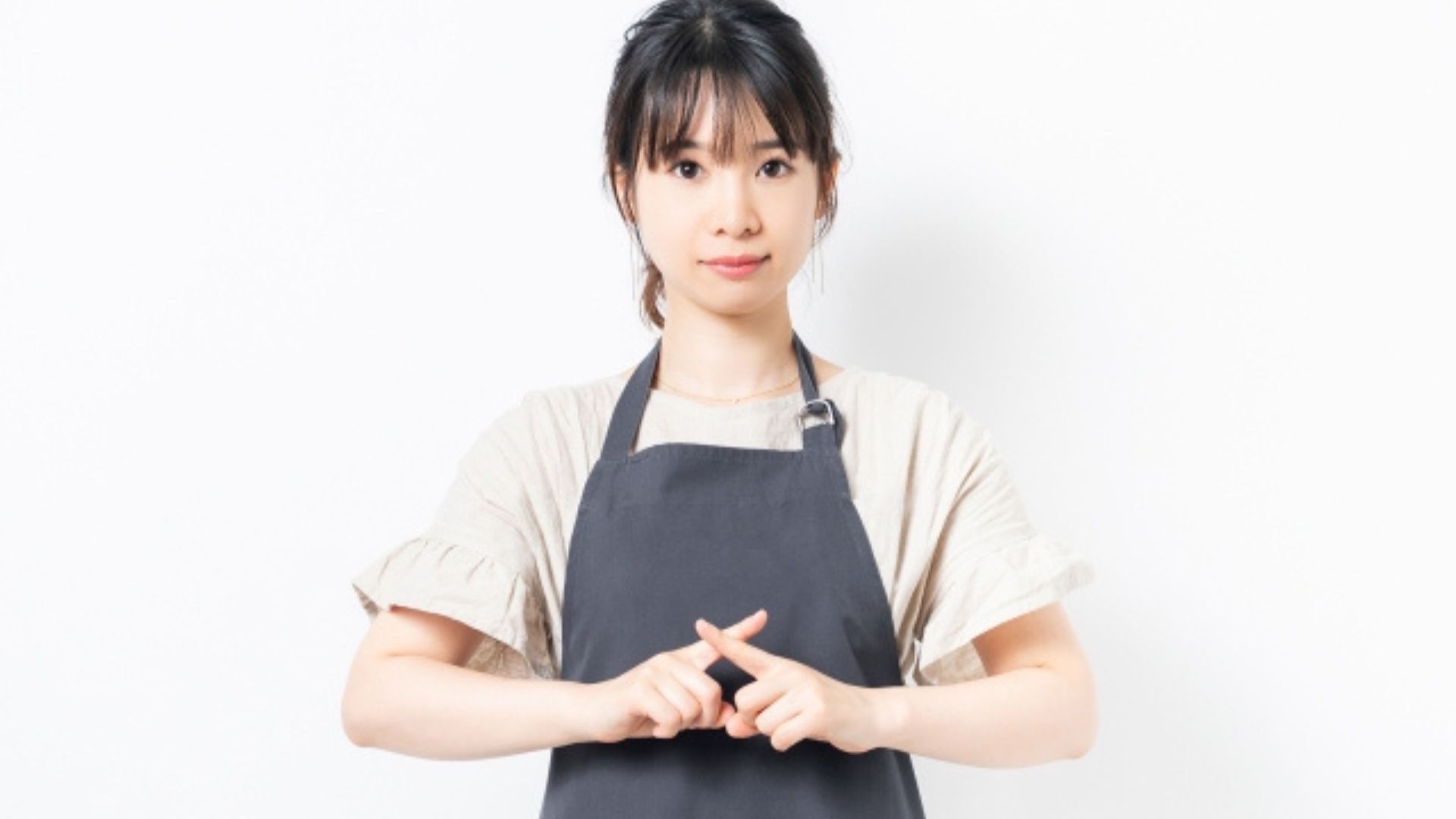 手でバツを作る女性