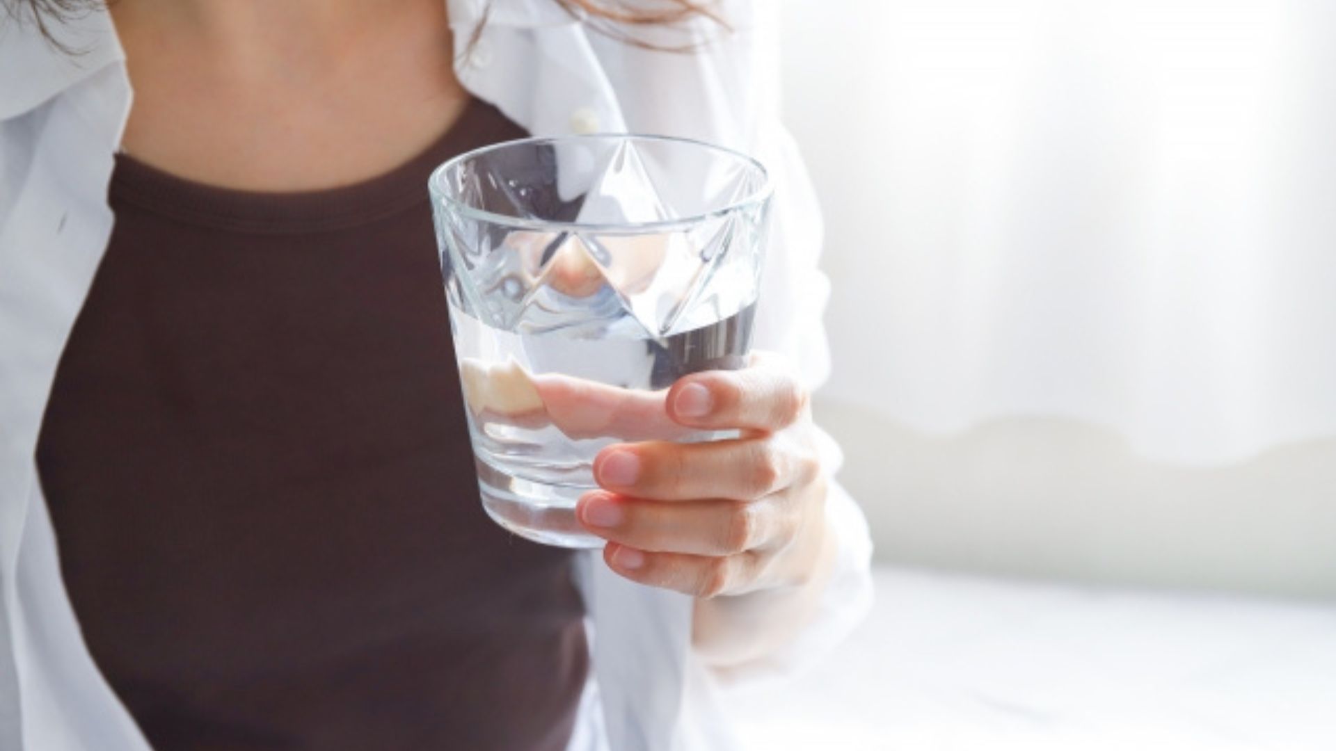 お水のグラスを持っている女性