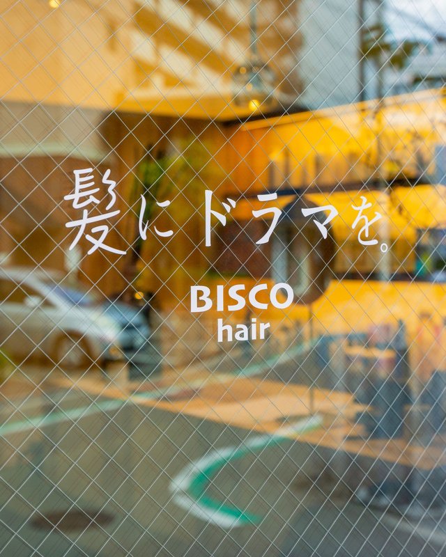 BISCOhair・髪にドラマを。直営店のガラス窓のロゴ
