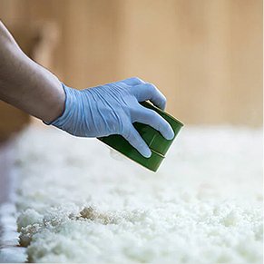 蒸し米を手入れする蔵人の手