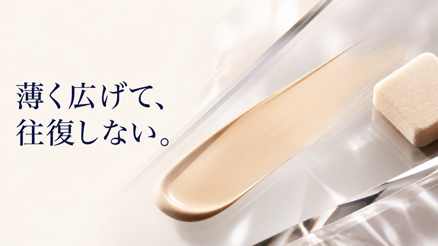 透明なガラス面でファンデーションの化粧膜が一方向へ薄く広がり、スポンジが終点で止まる静物画像