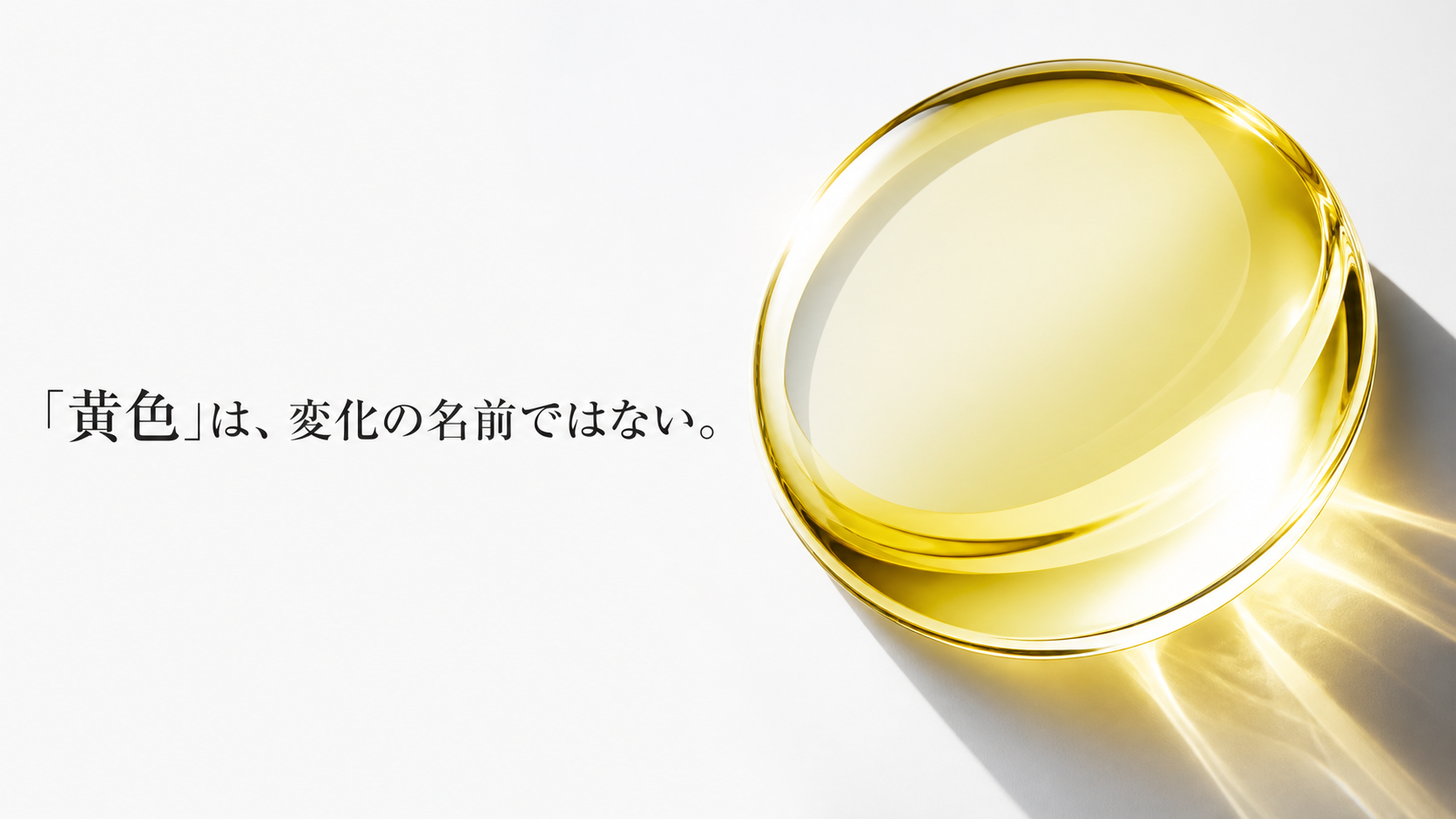 透明な淡黄色の一滴を通った光が白い面へプリズム状の影を落とす光学マクロ
