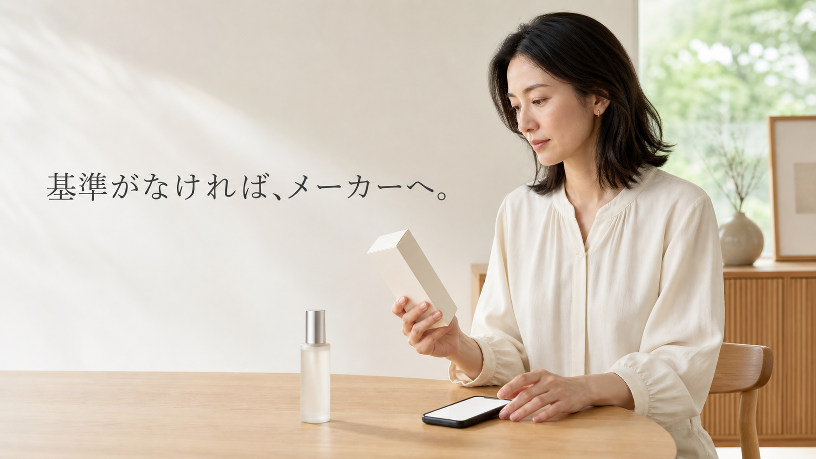 昼の居室で無地ボトルと外箱を手元に置き、スマートフォンでメーカー確認を準備する30代日本人女性