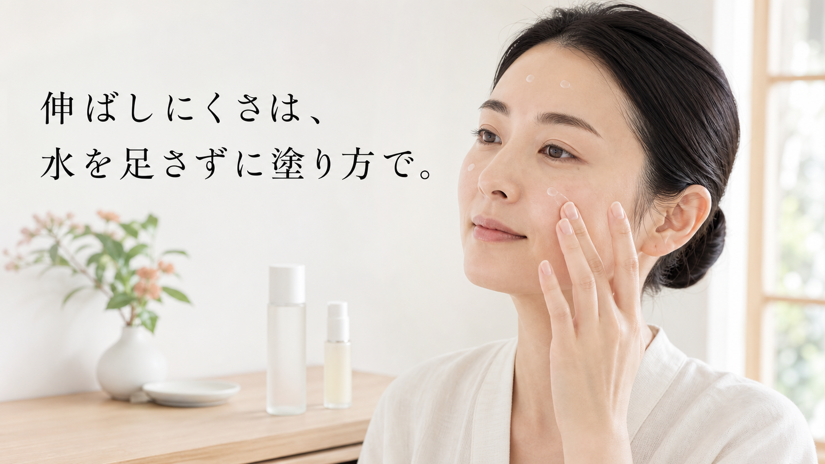 閉じた化粧水を背景に置き、美容液を顔の数か所へ置いてやさしく広げる30代女性の明るい生活写真