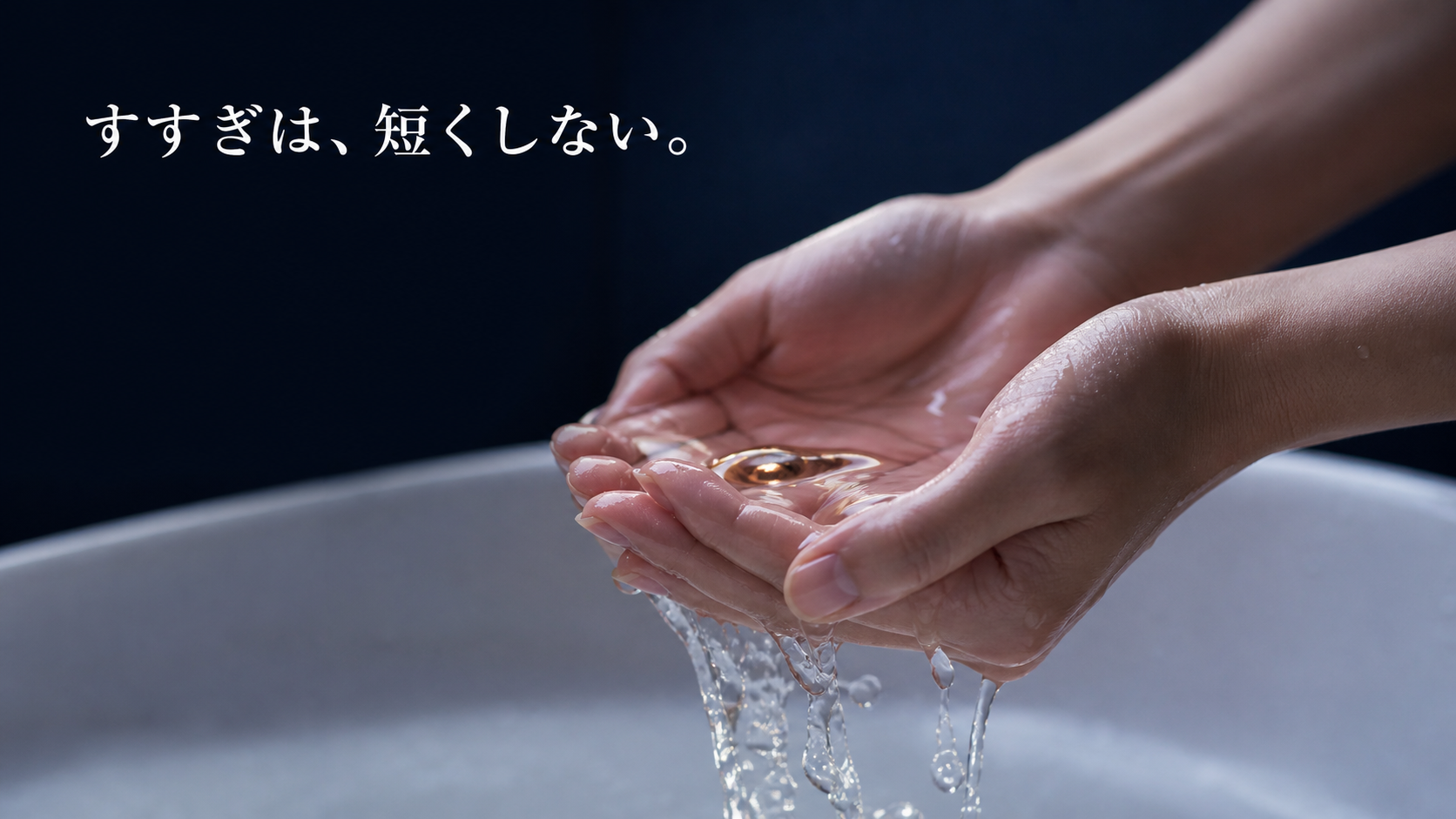 洗面ボウルの上で透明な水をやさしく受ける自然な両手の接写