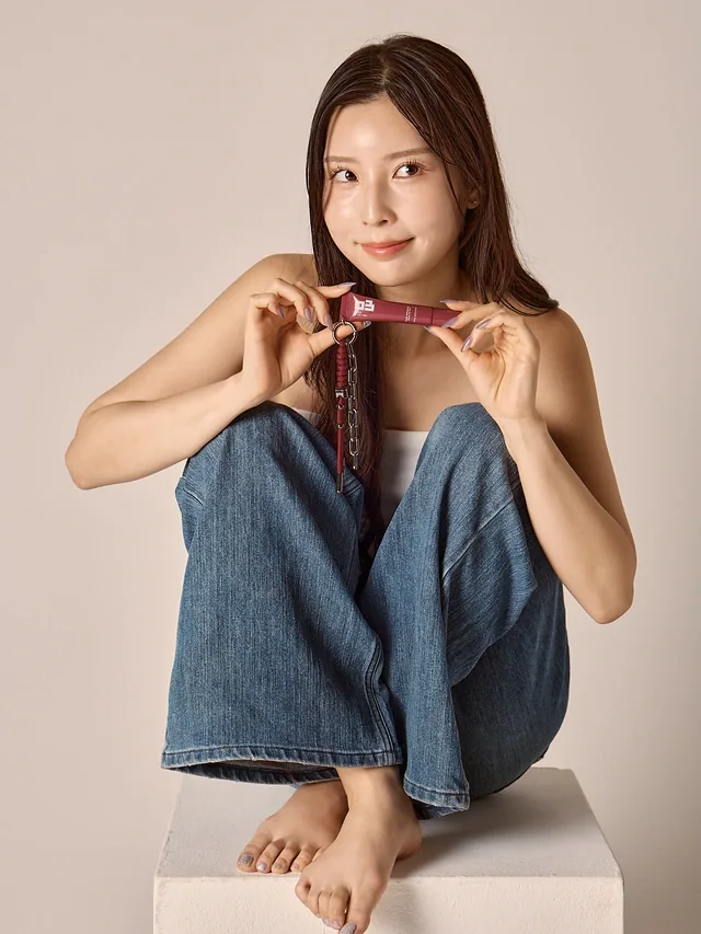キーループ付きティントを両手で持って微笑むモデル