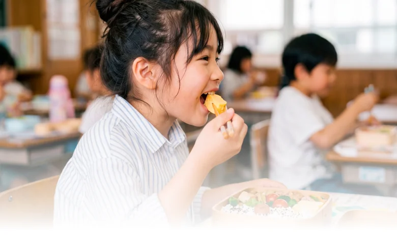 給食の時間にお弁当を楽しむ子どもたち