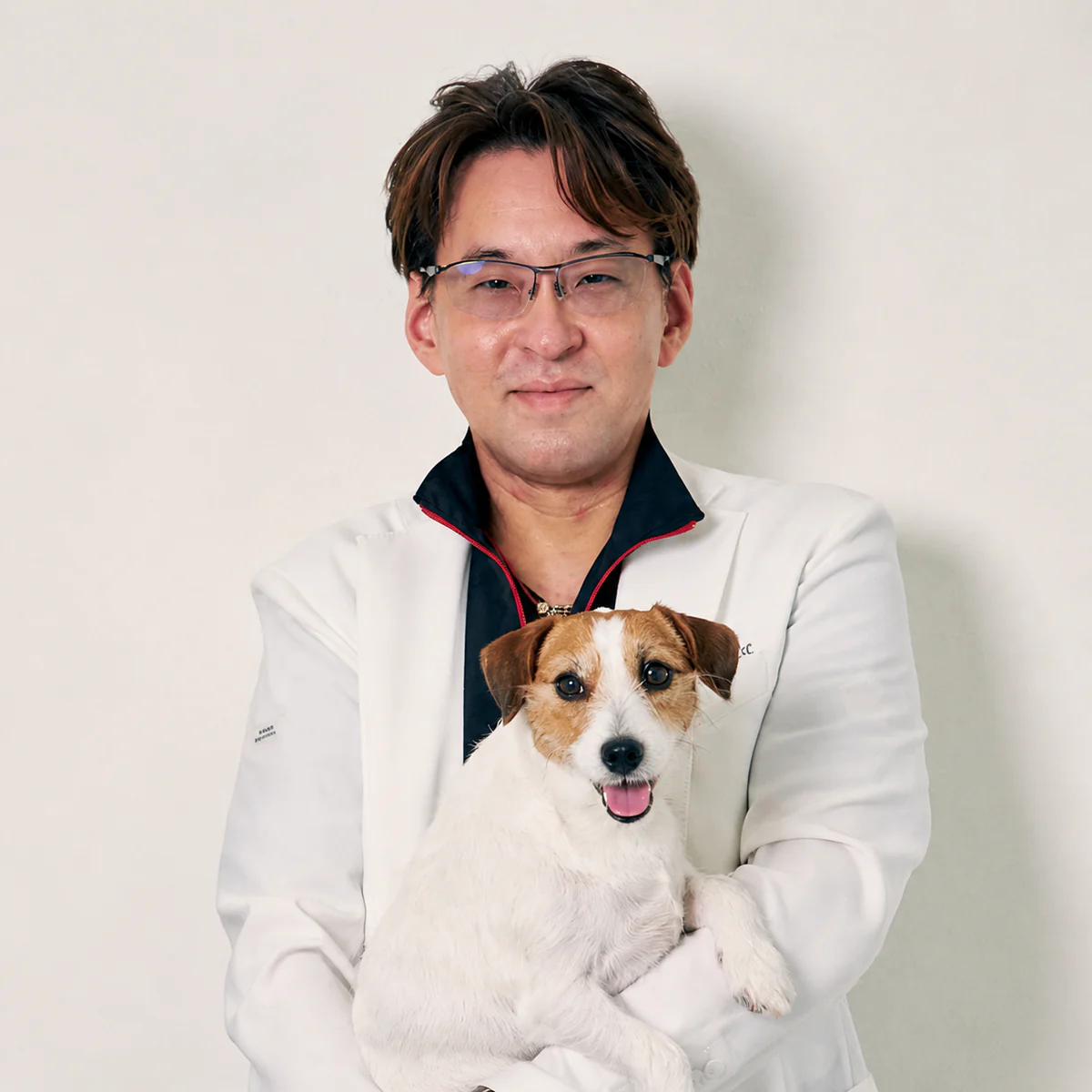 愛犬を抱く高井基普先生