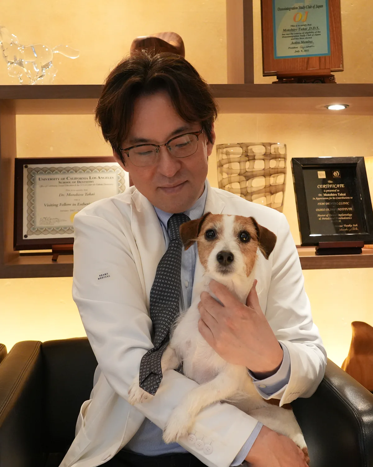 愛犬を抱く高井基普先生