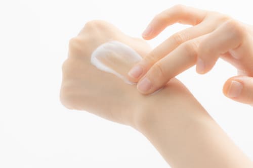 導入クリームを手の甲でなめらかに伸ばしている様子