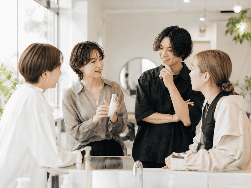 美容室で導入クリームについてスタッフ同士が情報共有している様子