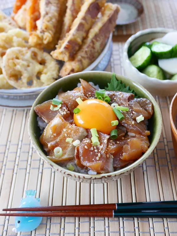 サカナDIYの漁師仕立ての海鮮丼に卵黄をのせ、野菜の天ぷらを添えた昼ごはん（@tomharemi さんのInstagram投稿）