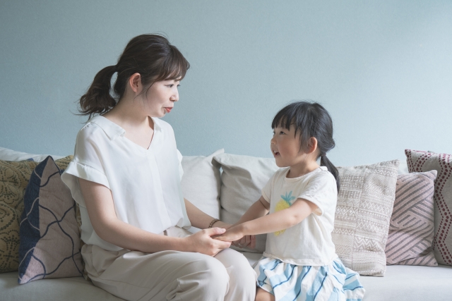 子どもの話を受け止める親の手