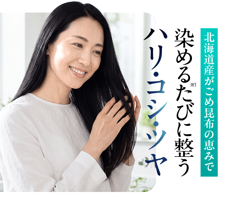 室内で長い黒髪に触れながら微笑む中年女性の写真 ハリ・コシ・ツヤ 北海道産がごめ昆布の恵みで
