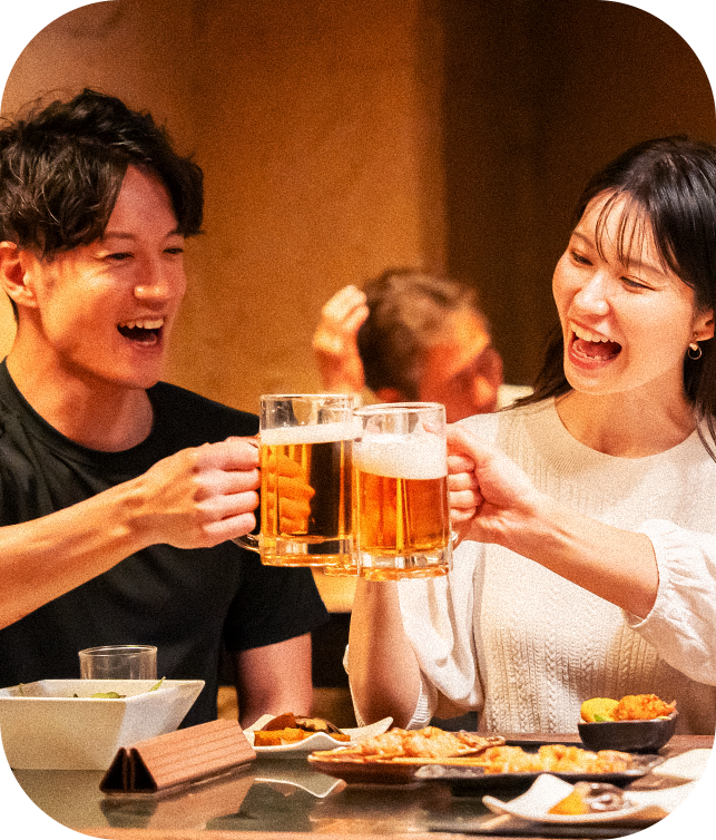 男女がビールで乾杯し楽しんでいる飲み会シーン